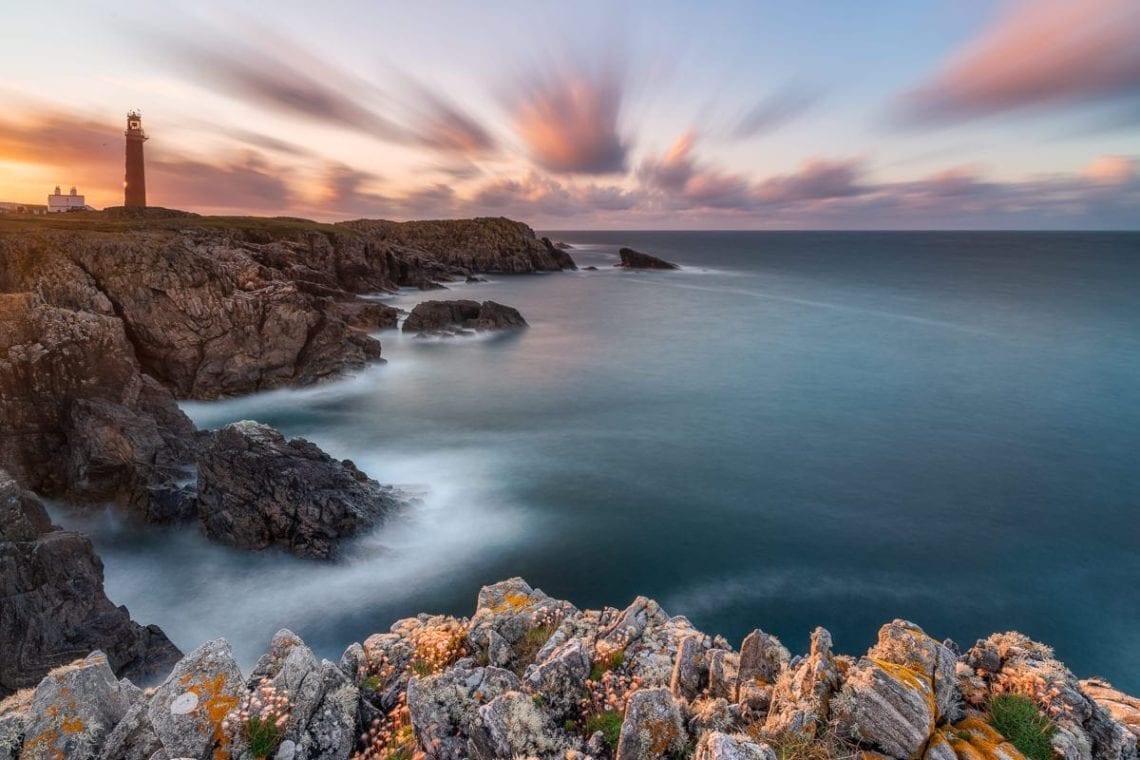 Lighthouse on the cliff at sunset